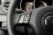 Mazda 3 Управление аудиосистемой продублировано клавишами на спице рулевого колеса, оформленного также с претензиями на спортивность